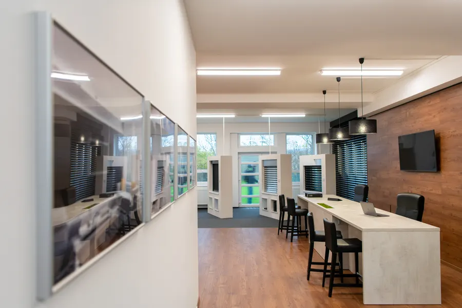 Průhled showroomem s výstavními okny a barovými židlemi